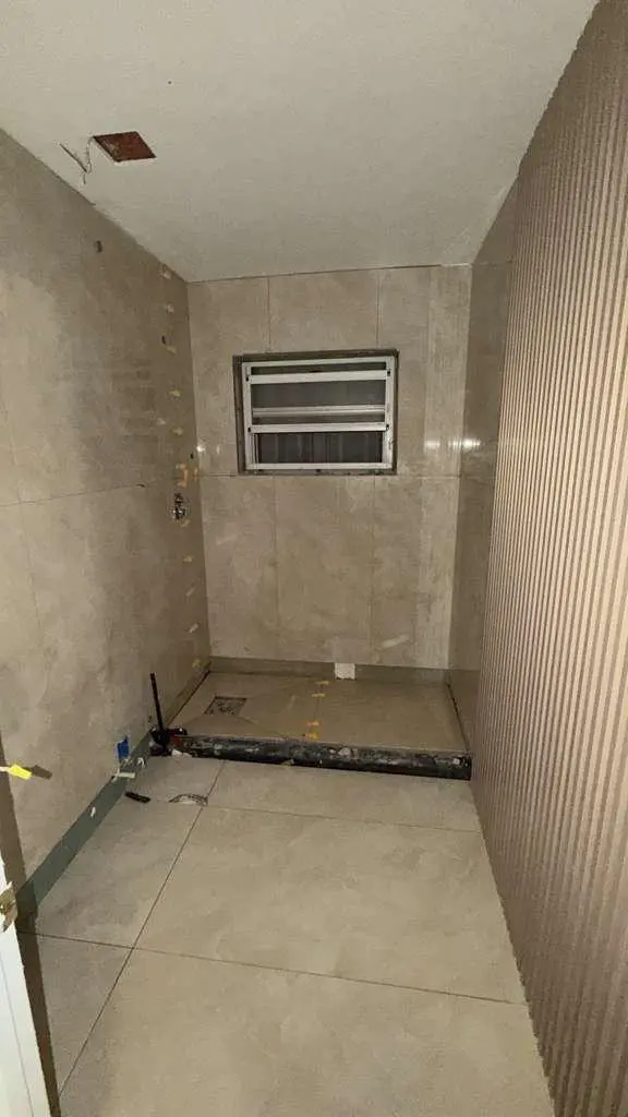 Shower area with tiled walls and a recessed niche during construction