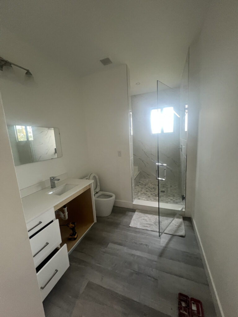 Bathroom with glass shower enclosure and white vanity